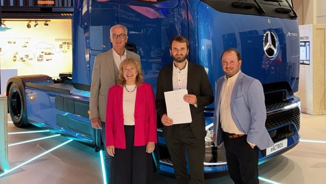 Im Rahmen des DACH-Kundenabends auf der IAA Transportation in Hannover hat die August Gschwander Transport GmbH aus Teningen einen Letter of Intent (LOI) zur geplanten Abnahme von 50 Zero-Emission-Trucks (ZEV) bis Ende 2030 unterzeichnet.
Mit der Unterzeichnung bekräftigt das familiengeführte Logistikunternehmen sein Engagement für die nachhaltige Transformation des Straßengüterverkehrs und setzt ein klares Zeichen für die Dekarbonisierung seiner Flotte.
Die August Gschwander Transport GmbH wird heute von Andreas Gschwander, Simon Gschwander und Markus Reichenbach in dritter Generation geführt. Die geplante Beschaffung von bis zu 50 batterieelektrischen Mercedes-Benz Trucks ist ein weiterer wichtiger Schritt auf dem Weg zu einer emissionsfreien Transportlogistik. Gleichzeitig unterstreicht die Vereinbarung die langjährige und vertrauensvolle Partnerschaft zwischen der Spedition Gschwander, Mercedes-Benz Trucks und der Kestenholz Gruppe. Bereits seit mehr als 50 Jahren arbeiten die Spedition Gschwander und Kestenholz erfolgreich zusammen.
Die unterzeichnete Absichtserklärung ist das Ergebnis intensiver Gespräche und einer langfristigen gemeinsamen Vorbereitung. Sie markiert einen weiteren Meilenstein der langjährigen Zusammenarbeit und unterstreicht das gemeinsame Ziel, nachhaltige Transportlösungen konsequent voranzutreiben.
Die Vereinbarung wurde im Beisein von Sylvia Diederichsmeier (Head of Sales Mercedes-Benz Trucks Deutschland), Christoph Forcher (Retailmanager Mercedes-Benz Trucks Deutschland), Simon Gschwander (Geschäftsführer der August Gschwander Transport GmbH) sowie Thomas Wolff (Centerleiter Lkw Vertrieb Deutschland, Kestenholz Gruppe) unterzeichnet.
Wir freuen uns darauf, diesen Weg gemeinsam fortzusetzen und die Zukunft nachhaltiger Logistik aktiv mitzugestalten.